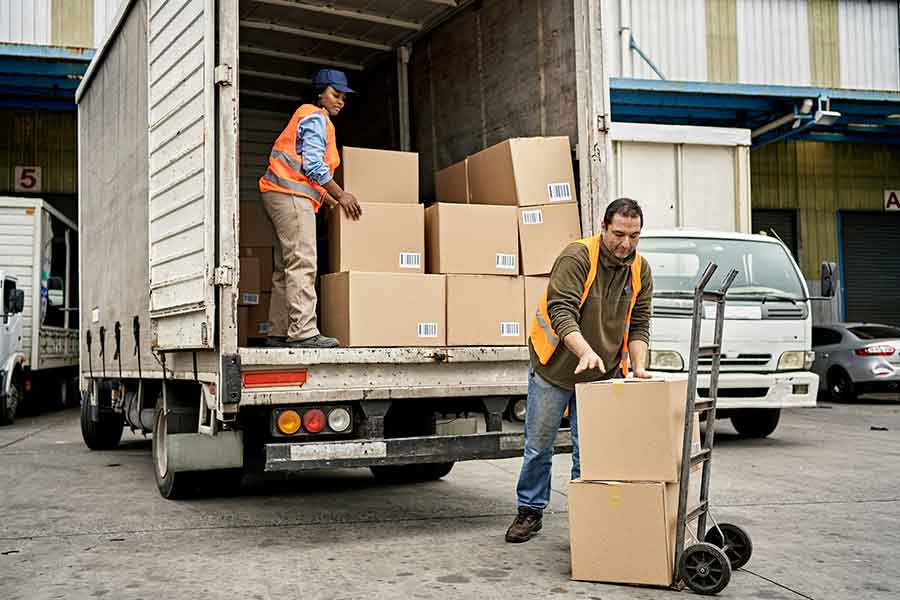 Commercial box truck being unloaded by two people