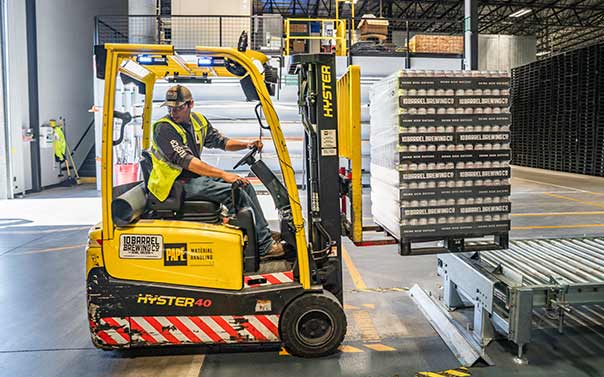 A warehouse worker driving a forklift