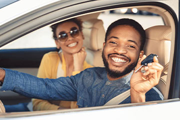 two people inside of a car smiling